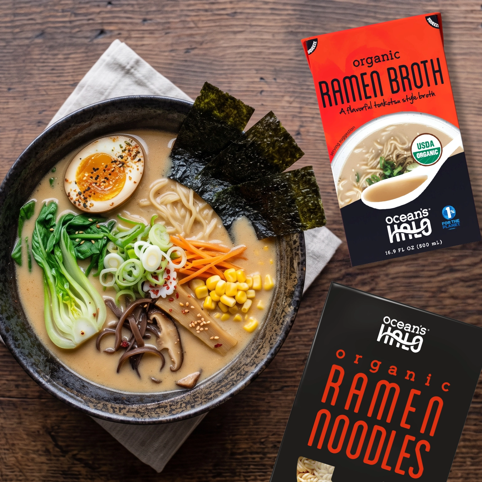 Bowl of ramen with egg, nori, and vegetables next to Ocean's Halo Ramen Broth and Noodles packaging.