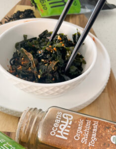A bowl filled with fresh greens, accompanied by chopsticks and a spoon, ready for a healthy meal.