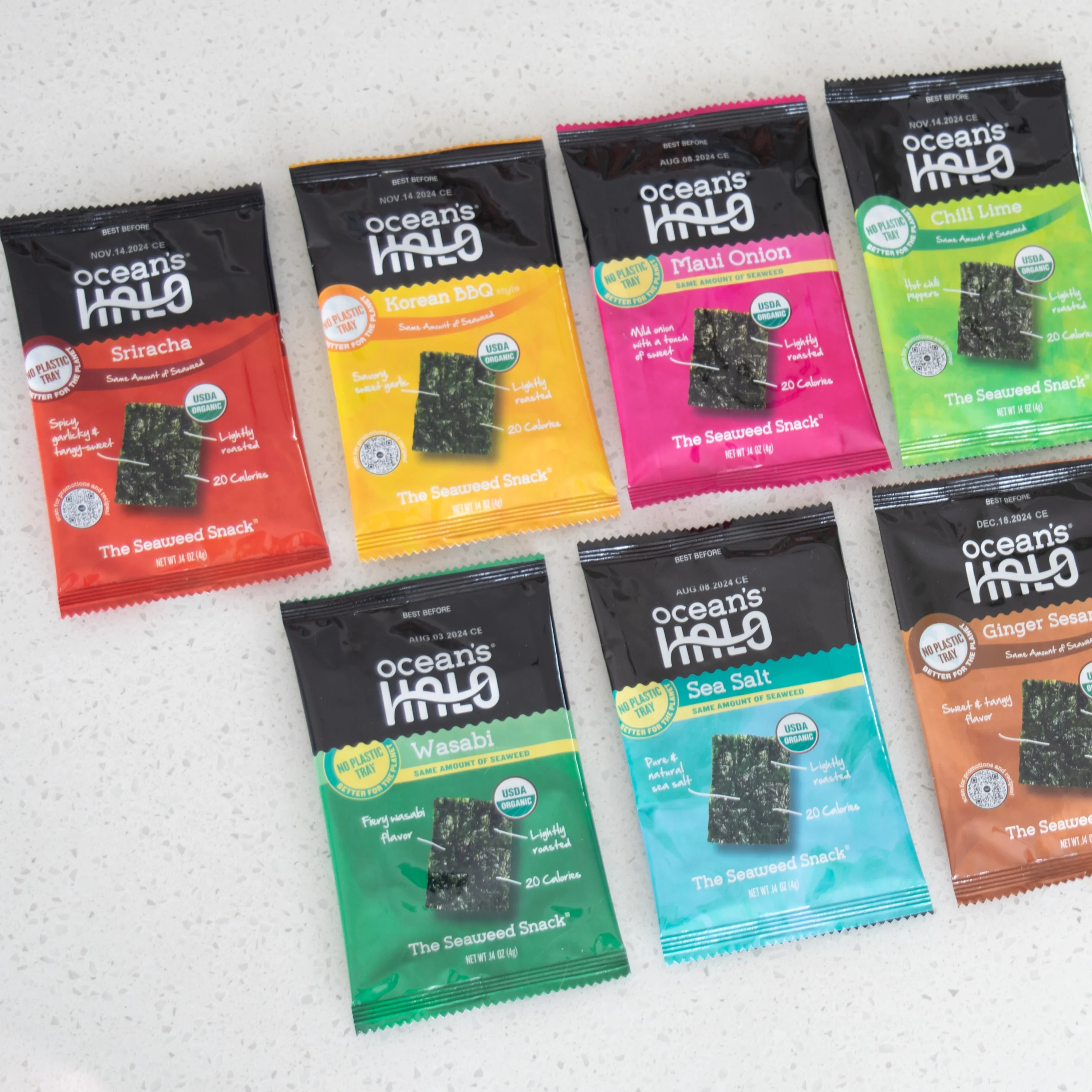 Flat lay of seven colorful Ocean's Halo seaweed snack packages arranged in two rows on a white counter.