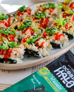 roasted seaweed snack bites on a plate topped with green onions & hot sauce with Ocean’s Halo Organic roasted Wasabi Seaweed Snack next to it.