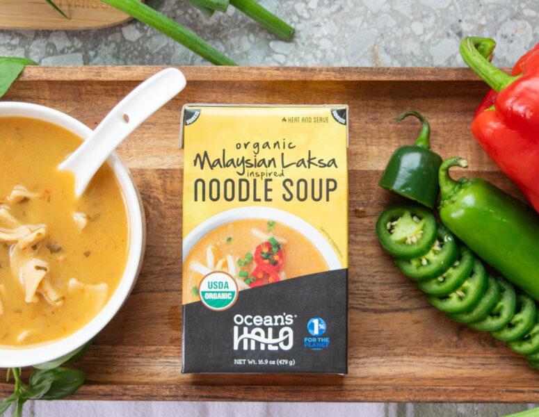 Ocean's Halo Malaysian Laksa Noodle Soup next to a bowl of soup and vegetables.